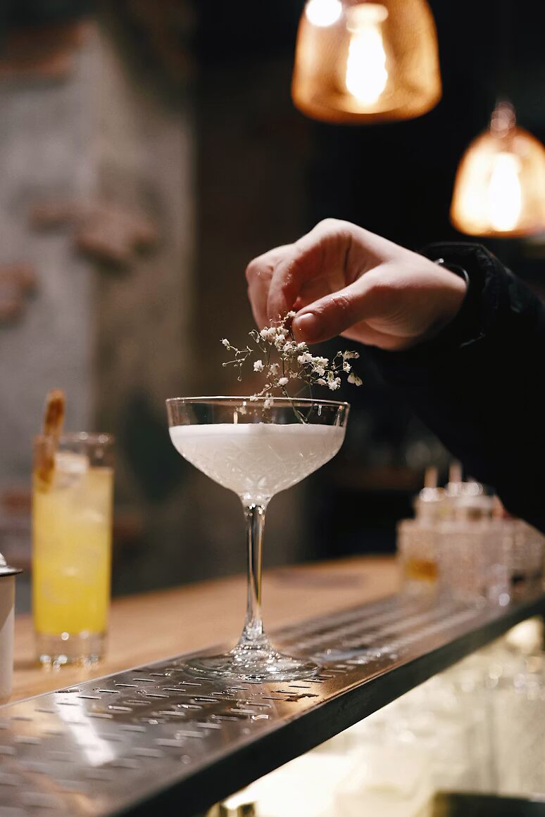Bartender werkt een cocktail af met een fijn bloemetje